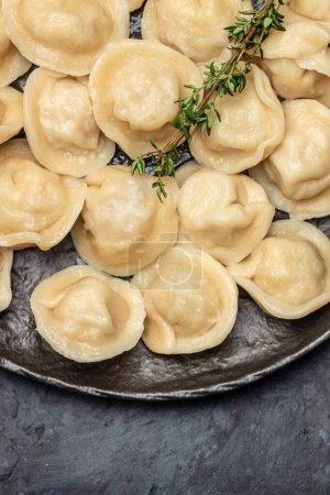 Photo for Traditional pelmeni, ravioli, dumplings with meat on a dark background. banner, menu, recipe place for text, top view - Royalty Free Image
