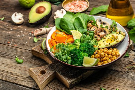 Veganer Salat aus grünem Gemüse mit Avocado, Champignons, Brokkoli, Spinat, Kichererbsen, Kürbis. Gesundes vegetarisches Essen. Ansicht von oben.