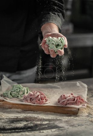 Photo for Chef makes fresh spaghetti, fettuccine or tagliatelle. cooking process. - Royalty Free Image