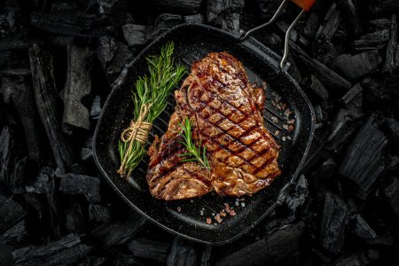 T-bone grilled beef steak with spices on a dark background. Restaurant menu, dieting, cookbook recipe ,