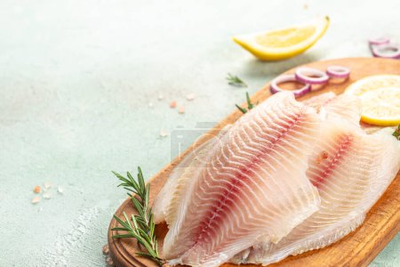 Foto de Filete de pescado crudo blanco tilapia sobre un fondo claro. vista superior. - Imagen libre de derechos
