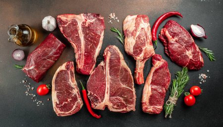 Téléchargez les photos : Variety of Raw Black Angus Prime steaks T-bone, tomahawk, New York steak. Définir les steaks de longe de boeuf marbrés crus. endroit pour le texte, vue du dessus. - en image libre de droit