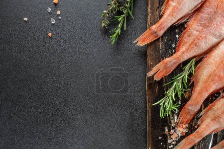 Téléchargez les photos : Snapper rouge poisson sur une planche à découper en bois sur un fond sombre. Concept d'alimentation saine. endroit pour le texte, vue du dessus. - en image libre de droit