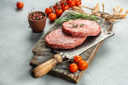 Téléchargez les photos : Viande de bœuf hachée crue côtelettes de steak burger sur une planche en bois, fond de recette alimentaire. Gros plan, - en image libre de droit