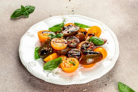 Foto de Ensalada de tomates frescos maduros con aceite de oliva y hojas de albahaca. comer limpio para bajar de peso. espacio de copia, vista superior, - Imagen libre de derechos