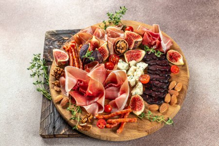 Photo for Apetizer platter. dry cured ham, prosciutto slices with figs and cheese. Delicious balanced food concept. - Royalty Free Image
