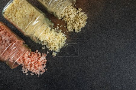 collection of different types of salt on a dark background. Long banner format. top view. copy space for text.