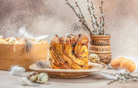 Delicious Easter bread cake with raisins and colorful eggs on festive Easter table. Swirl Bread or Brioche Bread. Homemade sweet desert.