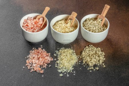 Three types of salt in bowls. Basil, paprika and lemon, cooking background. menu,