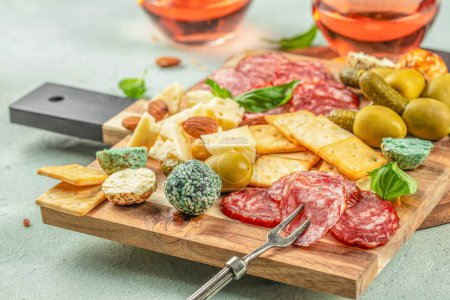 Table d'amuse-gueule avec différents antipasti salami, fromage et olives sur un fond clair vue de dessus. place pour le texte.