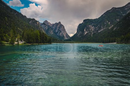 Photo for Alpine summer landscape with beautiful mountain lake. Toblacher see lake and green forest on the slopes, Dolomites, Italy Europe - Royalty Free Image