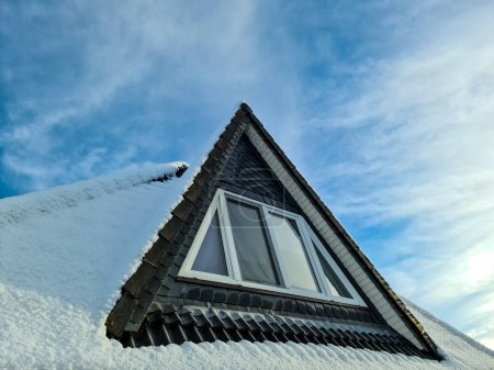 Téléchargez les photos : Open roof window in velux style with snow convered black roof tiles - en image libre de droit
