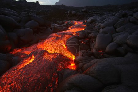 Foto de Un magma luminoso fluye en un campo de lava - Imagen libre de derechos