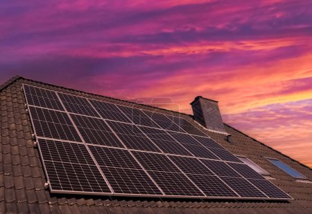 Photo for Solar panels producing clean energy on a roof of a residential house during sunset - Royalty Free Image