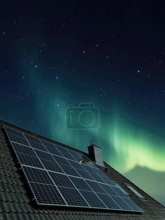 Photo for Solar panels producing clean energy on a roof of a residential house with aurora borealis in the background - Royalty Free Image