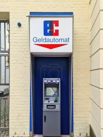 Foto de Kiel, Alemania - 27. Septiembre 2023: Un cajero automático de la CE en una pared al lado de un banco - Imagen libre de derechos