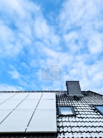 Photo for Snow covered solar panels producing clean energy on a roof of a house - Royalty Free Image