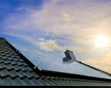 Solar panels producing clean energy on a roof of a residential house at sunset