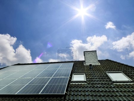 Solar panels producing clean energy on a roof of a residential house in the sunlight