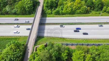 Drone view of a highway in Germany with a lot of traffic and many green fields around it