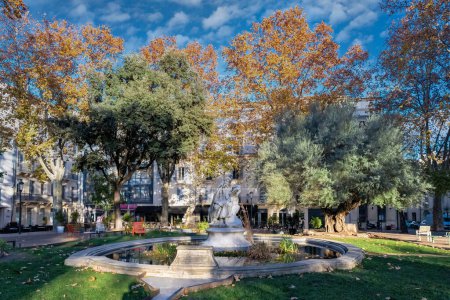 Téléchargez les photos : Ville de Nîmes en France, jolie place boisée dans le centre historique, bâtiments typiques - en image libre de droit