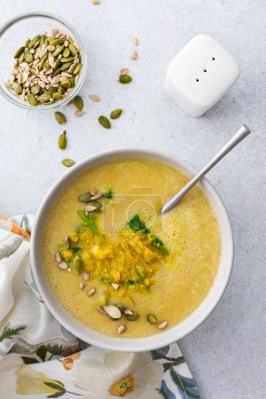 Photo for Healthy lunches, cream soup of yellow and orange lentils with fried onions and spinach leaves and curry, useful legums, top view - Royalty Free Image