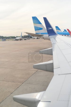 Foto de Buenos Aires, Argentina, 18 de noviembre de 2022: Vista desde una ventana sobre el ala de un avión Boeing 737-700 de Aerolineas Argentinas en la zona de embarque del Aeropuerto Internacional Jorge Newbery, - Imagen libre de derechos