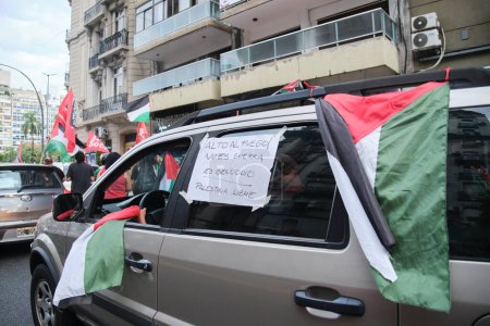 Foto de Buenos Aires, Argentina, 16 de febrero de 2024: Protesta en solidaridad con Palestina contra el ataque de Israel. Coche con banderas palestinas y un cartel: Alto al fuego. No es guerra, es genocidio. Palestina libre - Imagen libre de derechos