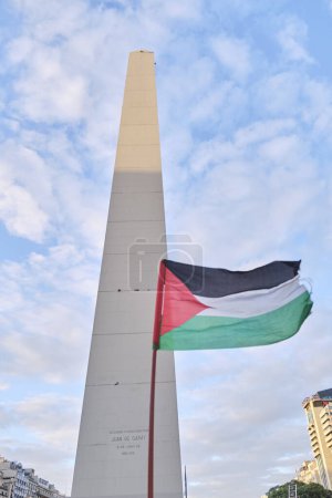 Foto de Buenos Aires, Argentina, 16 de febrero de 2024: Bandera palestina ondeando frente al obelisco, en el centro de la ciudad, durante una manifestación en solidaridad con Palestina y contra el ataque israelí y el genocidio sionista. - Imagen libre de derechos