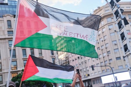 Foto de Buenos Aires, Argentina, 16 de febrero de 2024: Banderas palestinas ondeando durante una manifestación en solidaridad con Palestina y contra el ataque israelí y el genocidio sionista. - Imagen libre de derechos