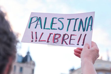 Foto de Buenos Aires, Argentina, 16 de febrero de 2024: personas protestando en solidaridad con Palestina contra el ataque genocida de Israel. Mujer irreconocible sosteniendo un cartel con el texto Free Palestine!! - Imagen libre de derechos