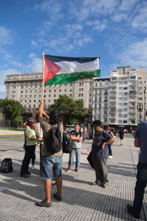 Foto de Buenos Aires, Argentina, 16 de febrero de 2024: Hombre levantando una bandera palestina, la gente se reunió frente al Congreso Nacional en apoyo y solidaridad con Palestina y contra el ataque genocida de Israel. - Imagen libre de derechos
