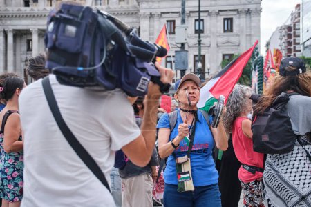 Foto de Buenos Aires, Argentina, 16 de febrero de 2024: camarógrafo filma a un grupo de personas protestando en solidaridad con Palestina y contra el ataque genocida de Israel. - Imagen libre de derechos