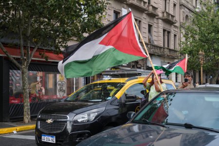 Foto de Buenos Aires, Argentina, 16 de febrero de 2024: Caravana de protesta en solidaridad con Palestina contra el ataque de Israel, gente ondeando banderas palestinas. - Imagen libre de derechos