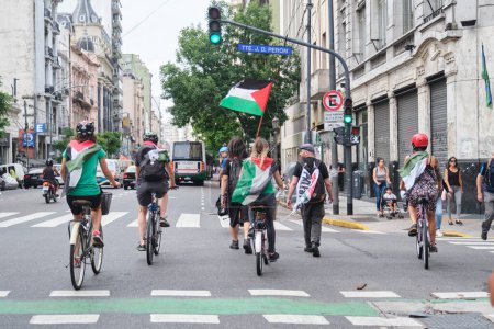 Foto de Buenos Aires, Argentina, 16 de febrero de 2024: Grupo de personas en bicicleta y caminando por el centro de la ciudad en solidaridad con Palestina contra el ataque genocida de Israel. - Imagen libre de derechos