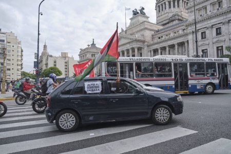 Foto de Buenos Aires, Argentina, 16 de febrero de 2024: Protesta en solidaridad con Palestina contra el ataque de Israel. Coche con bandera palestina y afiche: Alto al genocidio en Gaza. - Imagen libre de derechos