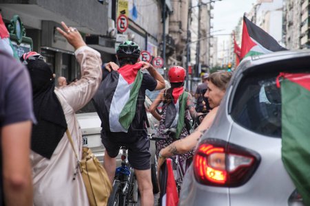 Foto de Buenos Aires, Argentina, 16 de febrero de 2024: Grupo de personas en coche, en bicicleta y caminando por el centro de la ciudad en solidaridad con Palestina contra el ataque genocida de Israel. - Imagen libre de derechos