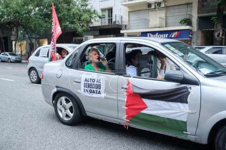 Foto de Buenos Aires, Argentina, 16 de febrero de 2024: Protesta en solidaridad con Palestina contra el ataque de Israel. Coche con bandera palestina y afiche: Alto al genocidio en Gaza! - Imagen libre de derechos