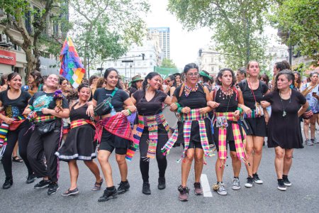 Téléchargez les photos : Buenos Aires, Argentine ; 8 mars 2024 : Groupe de femmes portant des textiles traditionnels colorés et agitant la danse wiphala tout en marchant pendant la grève féministe internationale. - en image libre de droit