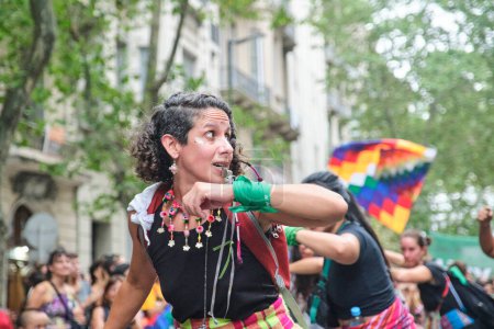 Téléchargez les photos : Buenos Aires, Argentine ; 8 mars 2024 : Femmes portant des textiles traditionnels colorés et agitant la danse wiphala lors de la marche pendant la grève féministe internationale. - en image libre de droit
