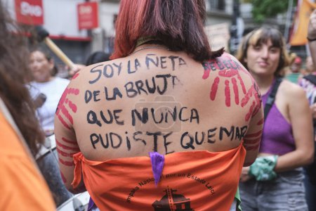 Téléchargez les photos : Buenos Aires, Argentine ; 8 mars 2024 : Femme montrant une écriture féministe sur le dos : Je suis la petite-fille de la sorcière que vous ne pourriez jamais brûler. Mouchoir orange, pour un état laïc. - en image libre de droit