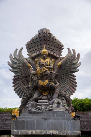 A grand statue of indonesian god, the mythical bird and national emblem of Indonesia, set against a cloudy sky
