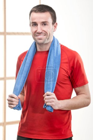 Foto de Hombre caucásico practicando fitness en gimnasio con camiseta roja y otros accesorios. - Imagen libre de derechos