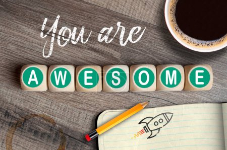 Photo for Cubes, dice or blocks with message you are awesome on wooden background with pencil, coffee and sketch bookSprache fr Keywords - Royalty Free Image