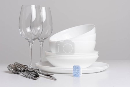Foto de Vasos vacíos con cubiertos sobre fondo blanco - Imagen libre de derechos