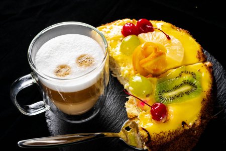 Foto de Sabroso pastel y café con leche en taza de vidrio en la mesa - Imagen libre de derechos