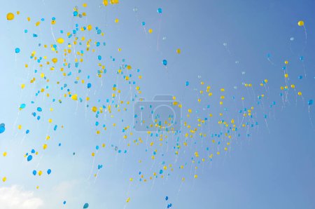 Foto de Hundread of balloons in Ukrainian national colors - blue and yellow flying in the blue sky - Imagen libre de derechos