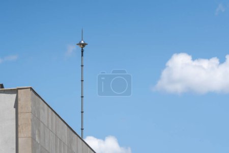Foto de Pararrayos en el techo de un edificio contra un cielo azul. Un rayo. - Imagen libre de derechos