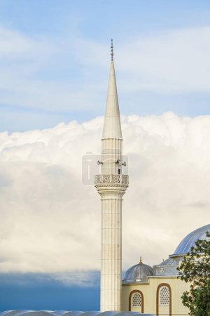 Foto de White mosque minaret. Mosque minaret with clouds in the background in Turkey - Imagen libre de derechos