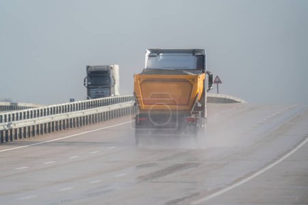 Sandlaster fahren im Regen auf der Autobahn. Autobahn im Regen.